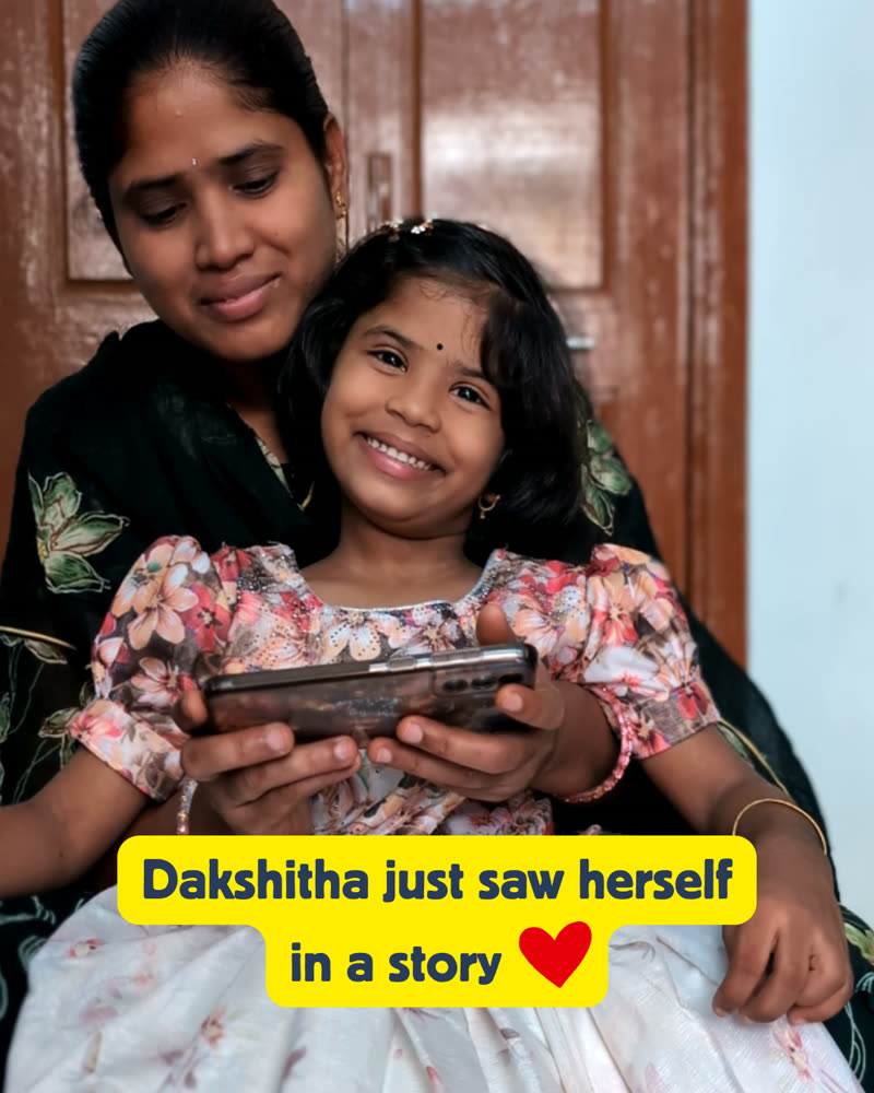 Dakshitha smiling on her mother's lap as she sees herself in a personalized Your Mitra story
